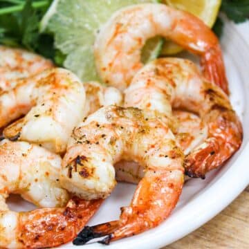 Grilled shrimp on a white plate.