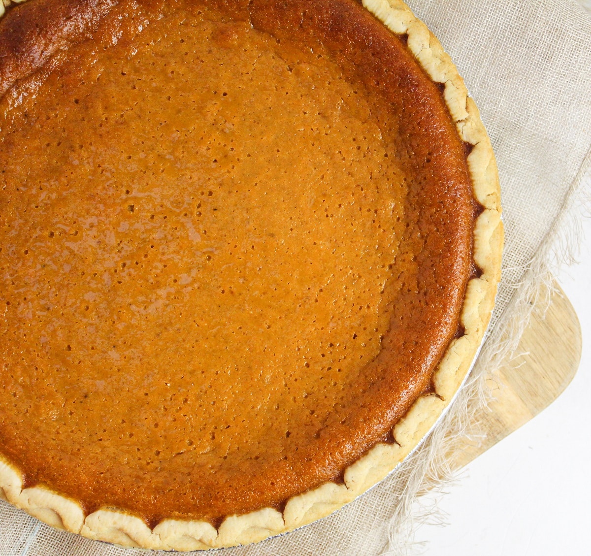 overhead photo of a pumpkin pie on a white background.