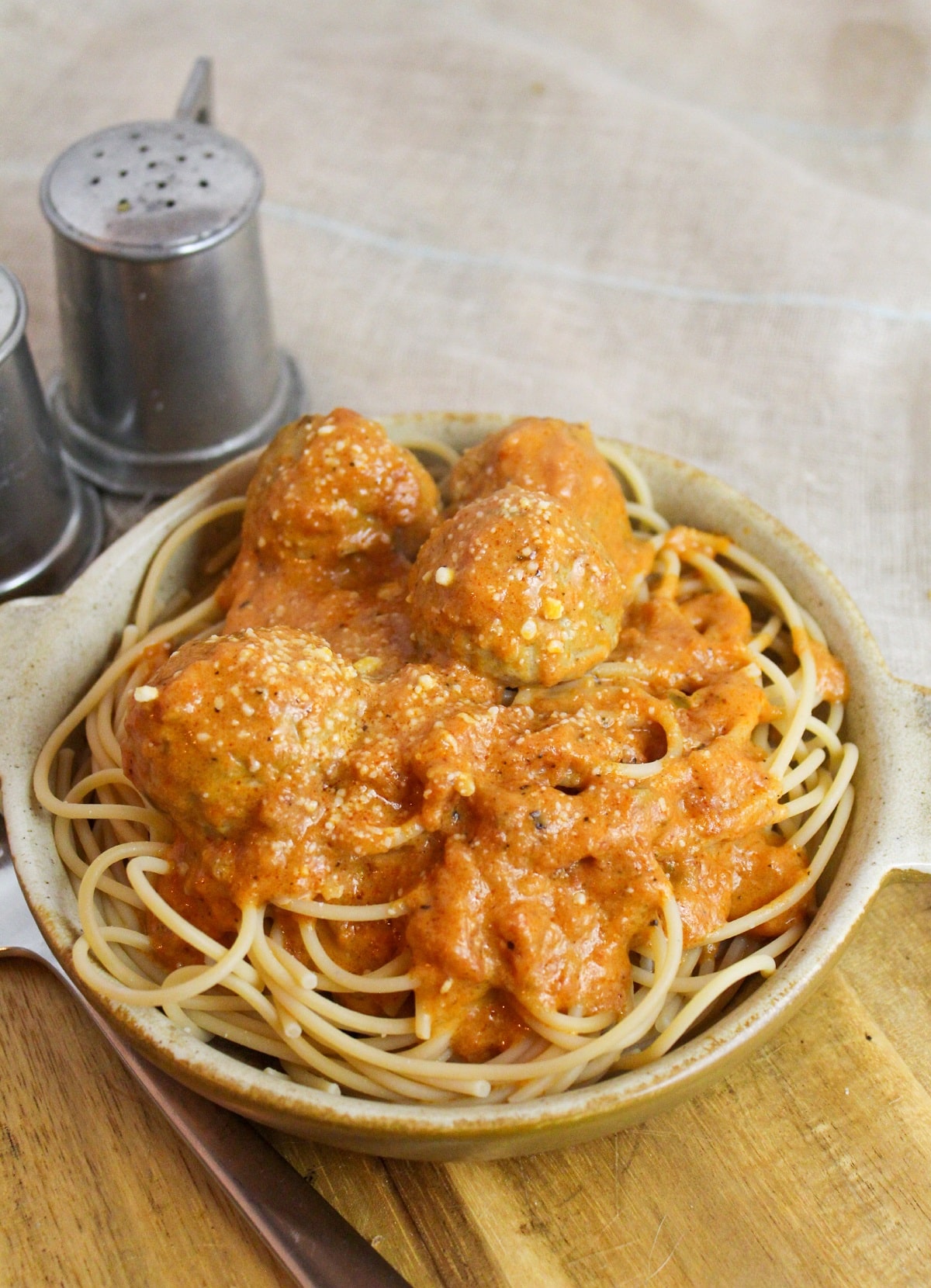 Meatballs cooked in a creamy tomato sauce over spaghetti.