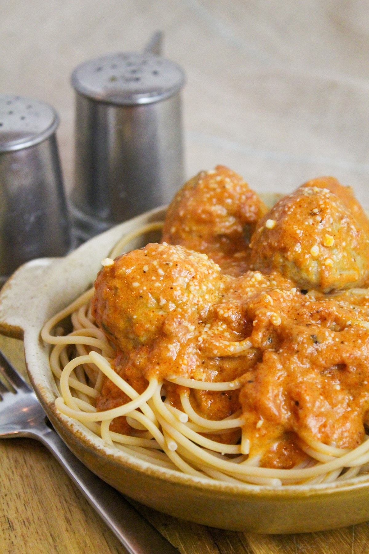 Meatballs cooked in a creamy tomato sauce over spaghetti.